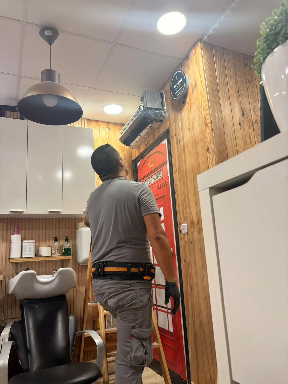 Técnico de Aires La Cala instalando un aire acondicionado en un local